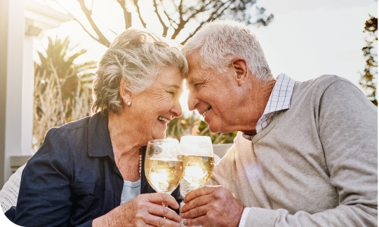 Couple celebrate signing their reverse mortgage loan agreement with a glass of wine.