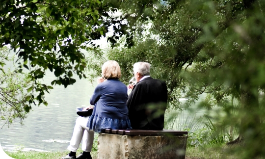A retired couple sit enjoying the view, free from financial stress with the help of a reverse mortgage.
